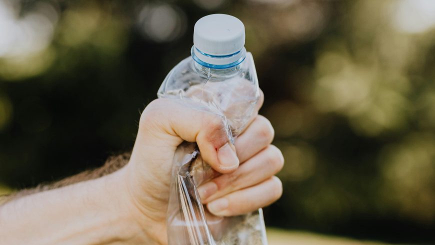 culte mâle écrasant la bouteille d'eau en plastique sur le campus