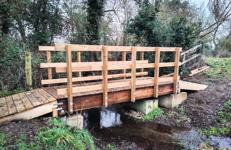 Des bénévoles construisent un nouveau pont dans la réserve des papillons pour pouvoir tondre l'herbe