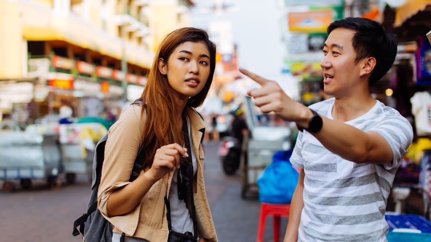 Fille demandant des informations lors d'un voyage, parlant à une personne locale