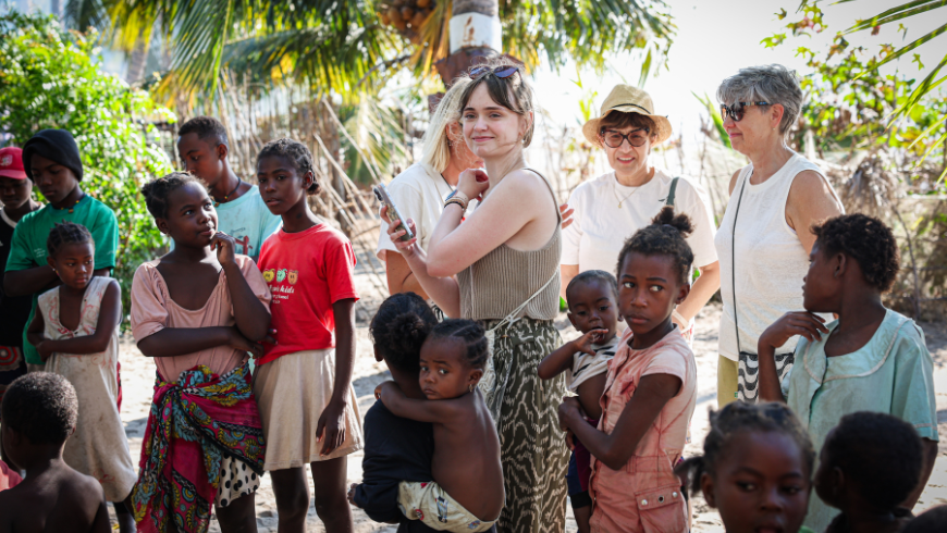 Des étudiants interagissent avec des membres d'une communauté locale à Madagascar lors d'un échange culturel dans le cadre d'une expérience de voyage durable.