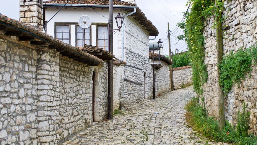Ruelle pavée étroite bordée de maisons ottomanes blanches traditionnelles dans la vieille ville historique de Berat, en Albanie.