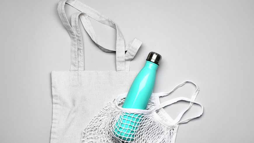 Bouteille d'eau réutilisable et sac en tissu pour un voyage plus durable.