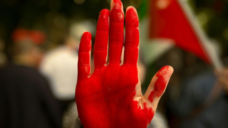 Main peinte en rouge d'un activiste protestant contre le génocide en Palestine