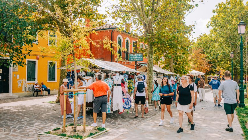 une scène de marché, avec des bâtiments colorés et des acheteurs d'été
